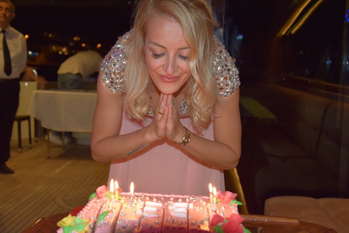 Blowing a birthday cake on a yacht